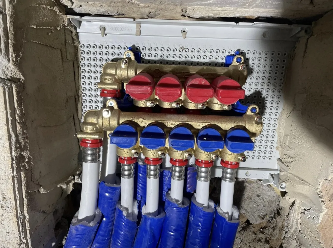 Collettore idrico professionale Teco in ottone con valvole rosse per l’acqua calda e blu per l’acqua fredda, in cassetta a incasso, Roma Piazza Fiume