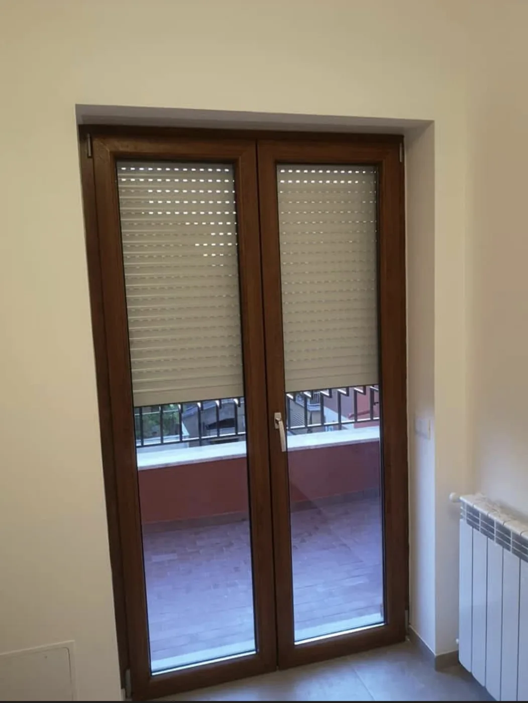 Porta-finestra a due ante in PVC Rehau color finto legno con tapparella, Roma Corso Trieste