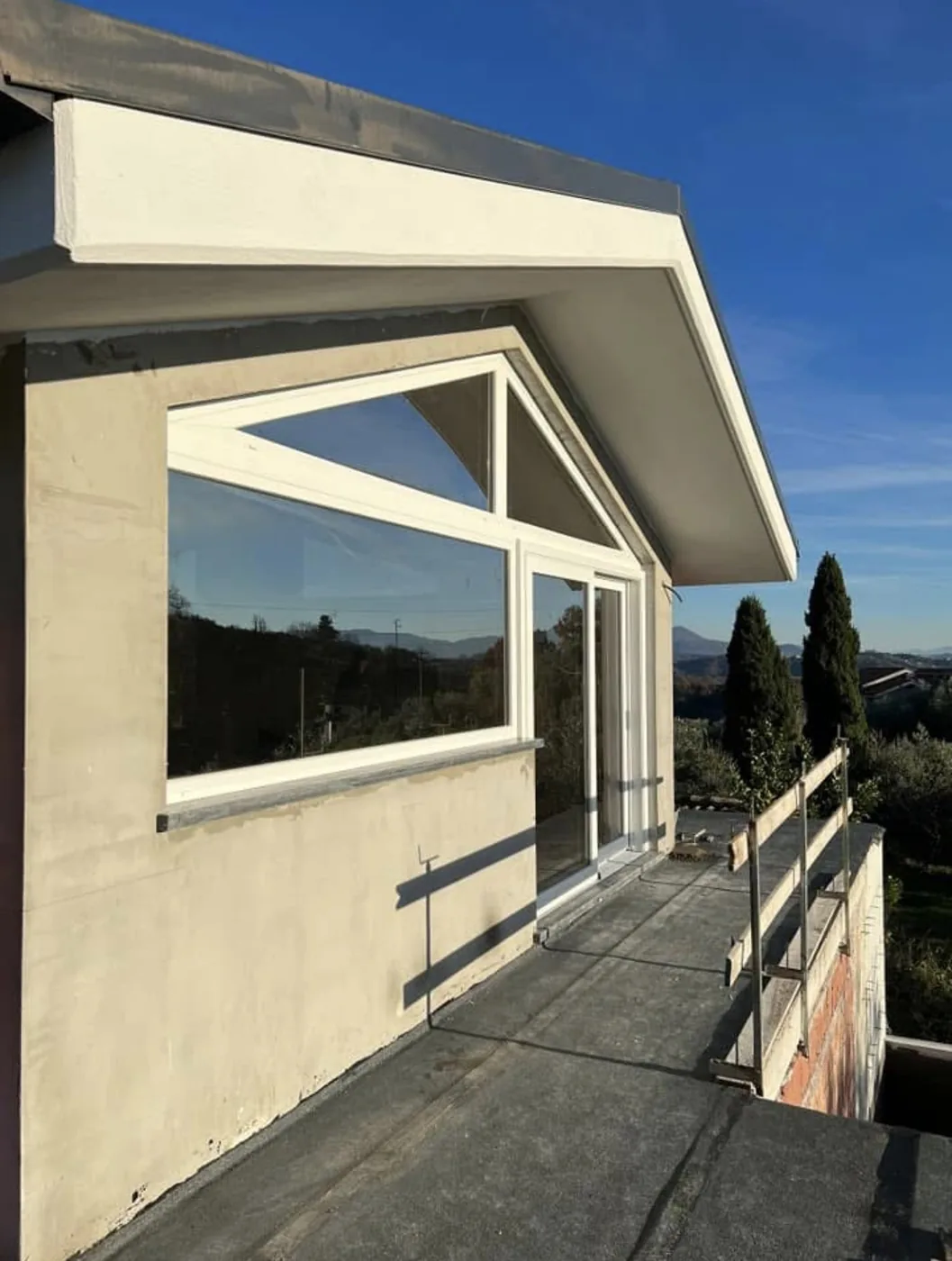 Vetrata con vetro a controllo solare riflettente e porta-finestra scorrevole vista dalla terrazza, Roma Nord