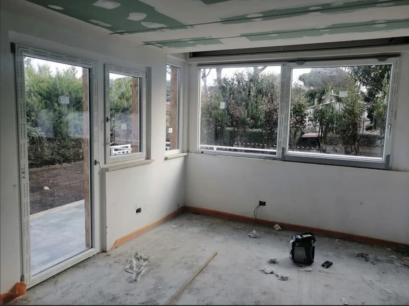 Porta-finestra e finestre in PVC Rehau Synego bianco montate nel soggiorno di una villa a Trigoria