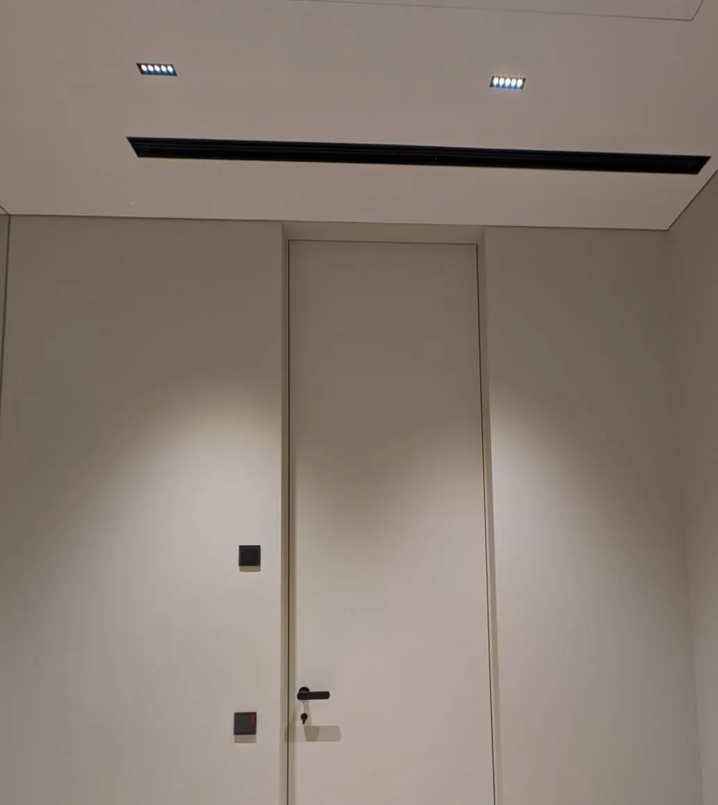 Porta filo muro a tutta altezza con faretti incassati e diffusore lineare, Roma Via Cassia