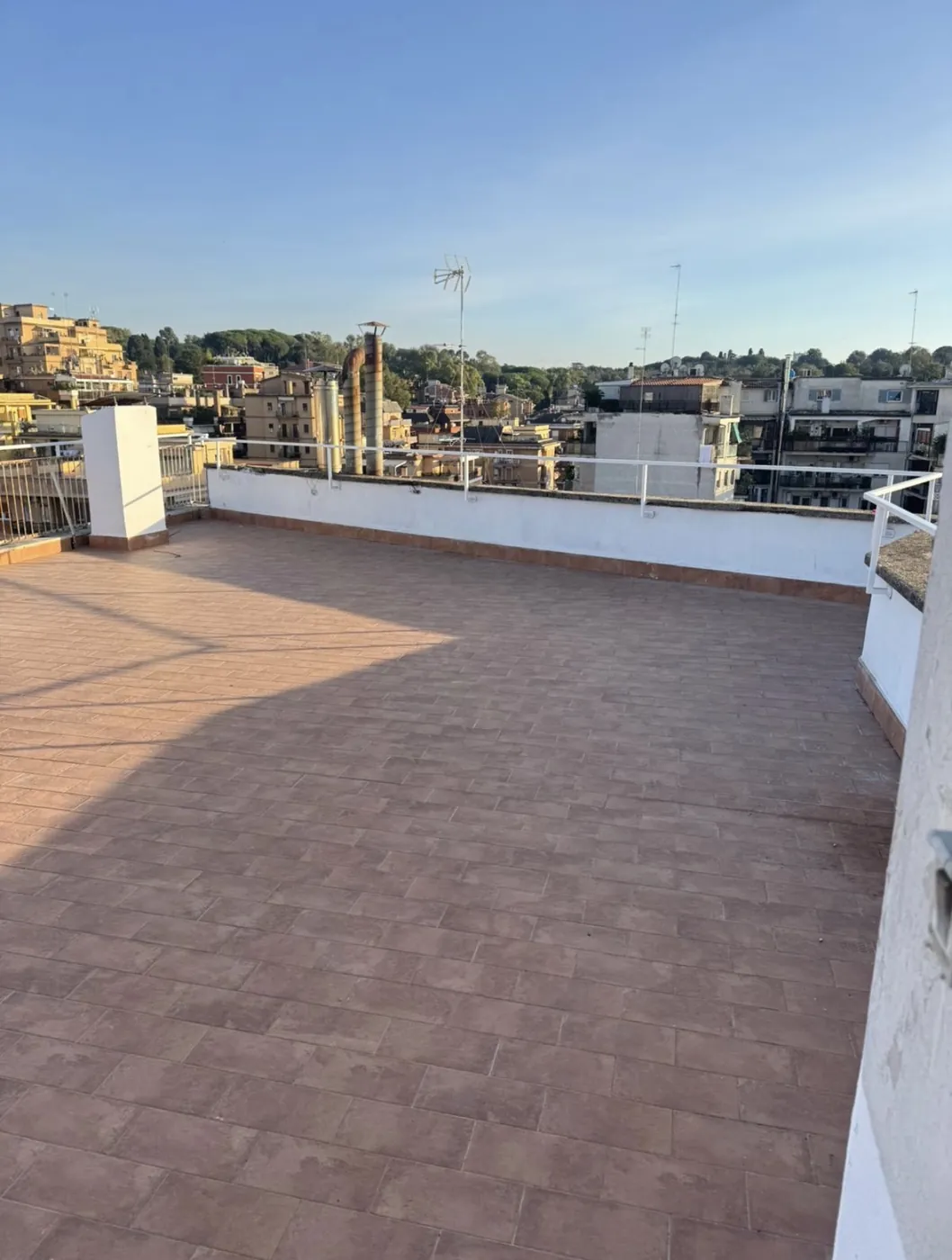 Pavimento in gres da esterno effetto cotto posato su un terrazzo a Roma, con battiscopa lungo i muretti