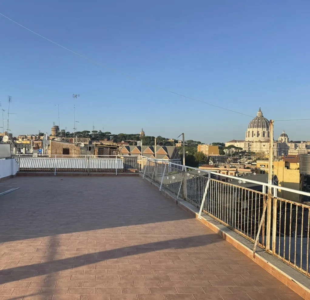Terrazzo rifatto a Roma con nuovo pavimento in gres effetto cotto e vista sulla cupola di San Pietro